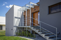 Jemný industriální prvek vstupního schodiště oživuje jednoduché tvary stavby