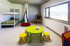 Prostorný dětský pokoj má teplou dřevěnou podlahu. Zatím je rozdělen na úložný prostor, spací zónu a zónu na hraní. Vybavení se postupně přizpůsobí věku dětí
