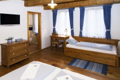 Pokoje jsou tematicky vybaveny i pojmenovány, na obrázku vidíte Modrý pokoj s dveřmi do koupelny. Nábytek v celém domě je vyroben na zakázku ve stylu našich prababiček