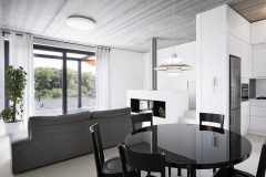 Bílé a lesklé povrchy odrážejí světlo a napomáhají dokonalému prosvětlení interiéru. Rozdíl mezi úrovní podlah ve společné obývací části a v ložnicích vyrovnává malé schodiště
