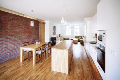 Odstraněním příčky vznikl velkorysý prostor zahrnující kuchyň, jídelní kout, relaxační respirium a obývací pokoj