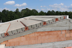 Po uložení panelů se po obvodu střechy vyzdí věncovky, za které se vkládá tepelná izolace. Poté se vyztuží druhá úroveň podélného věnce, realizuje se také výztuž po obvodu střechy