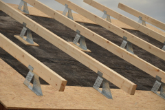 Na zabetonované stropní panely se pokládá hydroizolace ve formě asfaltových pásů, která plní funkci i parozábrany a vzduchotěsné vrstvy (pokud se neprovádějí vnitřní omítky). Na ocelové profily se uloží pomocné krokve, kterými se vymezí prostor pro tepelnou izolaci